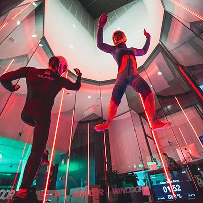 Descubre una exhibición impresionante donde nuestros voladores combinan acrobacias aéreas y danza en el túnel de viento. Al ritmo de la música, cada giro y pirueta desafía la gravedad, creando una experiencia visual única.